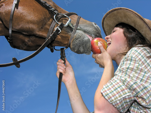 Photo: young cowgirl and her friend eating an apple young cowgirl and her friend eating an apple