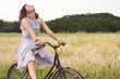 Photo: Pretty young woman riding bike in a country road. Pretty young woman riding bike in a country road.