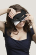 Portrait of a young woman wearing cat mask over gray background