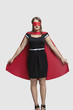 Young woman standing in superhero costume over gray background