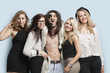Foto: Portrait of playboy and happy women standing together against light blue background Portrait of playboy and happy women standing together against light blue background