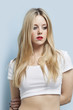 Foto: Beautiful blond woman with red lips looking down against light blue background Beautiful blond woman with red lips looking down against light blue background