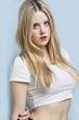 Foto: Portrait of beautiful young blond woman with red lips over light blue background Portrait of beautiful young blond woman with red lips over light blue background