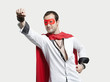 Young man wearing superhero costume against gray background
