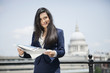 Foto: Portrait of Indian businesswoman holding newspaper with St. Paul's Cathedral in background Portrait of Indian businesswoman holding newspaper with St. Paul's Cathedral in background