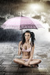 sexy brunette with umbrella, sitting with crossed legs