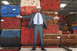Photo: Portrait of happy African American male engineer standing with arms outstretched in front of stacked wooden planks Portrait of happy African American male engineer standing with arms outstretched in front of stacked wooden planks