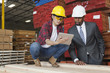Female industrial worker showing something on tablet PC to male engineer