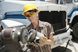 Female industrial worker buffing a truck engine cylinder