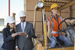 Photo: Engineers using tablet PC with female industrial worker driving forklift truck Engineers using tablet PC with female industrial worker driving forklift truck