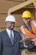 Photo: African American businessman and female industrial worker looking at tablet PC African American businessman and female industrial worker looking at tablet PC