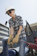 Mid adult woman holding a break hose of a logging truck
