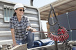 Mid adult woman holding a break hose of a flatbed truck