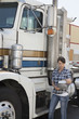 Woman looking at clipboard while standing by flatbed truck