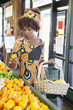 Photo: African American woman in traditional wear shopping for fruits at supermarket African American woman in traditional wear shopping for fruits at supermarket