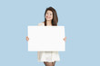 Photo : Portrait of a beautiful young woman holding blank cardboard over blue background Portrait of a beautiful young woman holding blank cardboard over blue background