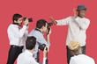 Young male celebrity shielding face from photographers over red background