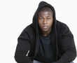 Photo: Portrait of a trendy African American man wearing hooded sweatshirt over gray background Portrait of a trendy African American man wearing hooded sweatshirt over gray background
