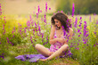 Beautiful young woman in purple flowers outdoors