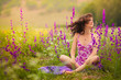 Beautiful young woman running in purple flowers outdoors