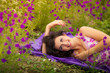 Beautiful young woman in purple flowers outdoors