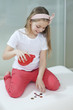 Young girl with piggy bank counting coins on bed