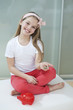 Portrait of girl with piggy bank and coins sitting in bed