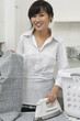 Portrait of young housemaid ironing trousers