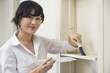 Portrait of female housekeeper cleaning shelf