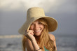 Photo : blond woman with sunhat on the beach blond woman with sunhat on the beach