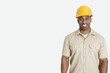 Photo: Portrait of happy young African man wearing yellow hard hat helmet over gray background Portrait of happy young African man wearing yellow hard hat helmet over gray background