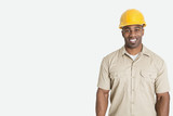 Photo: Portrait of happy young African man wearing yellow hard hat helmet over gray background Portrait of happy young African man wearing yellow hard hat helmet over gray background