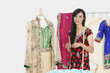 Photo: Portrait of Indian female dressmaker standing by a dummy dressed in traditional wear Portrait of Indian female dressmaker standing by a dummy dressed in traditional wear