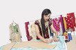 Photo : Indian female clothing designer working in design studio Indian female clothing designer working in design studio