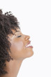Photo: Profile view of an African American woman smiling with eyes closed against gray background Profile view of an African American woman smiling with eyes closed against gray background