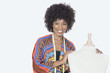 Photo: Portrait of African American female fashion designer with tailor's dummy over gray background Portrait of African American female fashion designer with tailor's dummy over gray background
