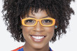 Photo: Close-up portrait of an African American woman wearing glasses over gray background Close-up portrait of an African American woman wearing glasses over gray background