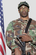 Foto: US Marine Corps soldier with M4 assault rifle standing by American flag over gray background US Marine Corps soldier with M4 assault rifle standing by American flag over gray background