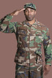 Foto: Portrait of a young African American US Marine Corps soldier saluting over brown background Portrait of a young African American US Marine Corps soldier saluting over brown background