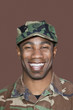 Foto: Portrait of a cheerful young African American US Marine Corps soldier over brown background Portrait of a cheerful young African American US Marine Corps soldier over brown background