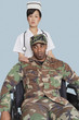 Foto: Female nurse comforting disabled US Marine Corps soldier in wheelchair over light blue background Female nurse comforting disabled US Marine Corps soldier in wheelchair over light blue background