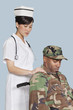 Foto: Female nurse comforting disabled US Marine Corps soldier in wheelchair over light blue background Female nurse comforting disabled US Marine Corps soldier in wheelchair over light blue background