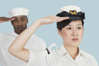 Foto: Portrait of serious female US Navy officer and male sailor saluting over light blue background Portrait of serious female US Navy officer and male sailor saluting over light blue background