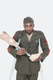 Photo: Portrait of a disabled US military officer holding prosthesis leg over gray background Portrait of a disabled US military officer holding prosthesis leg over gray background