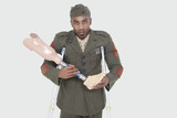 Photo: Portrait of a disabled US military officer holding prosthesis leg over gray background Portrait of a disabled US military officer holding prosthesis leg over gray background