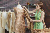 Photo: Young female fashion designer matching cloth with fabric draped on tailor's dummy Young female fashion designer matching cloth with fabric draped on tailor's dummy