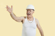 Senior male constructor shouting over yellow background