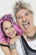 Photo: Portrait of senior punk couple with man sticking out tongue over gray background Portrait of senior punk couple with man sticking out tongue over gray background