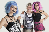 Photo: Group portrait of young female punk with senior couple standing in background Group portrait of young female punk with senior couple standing in background