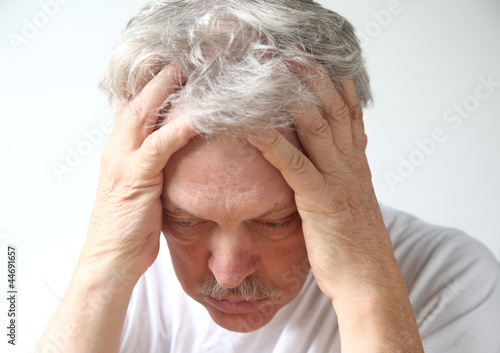 Photo: senior man holds his head in despair senior man holds his head in despair